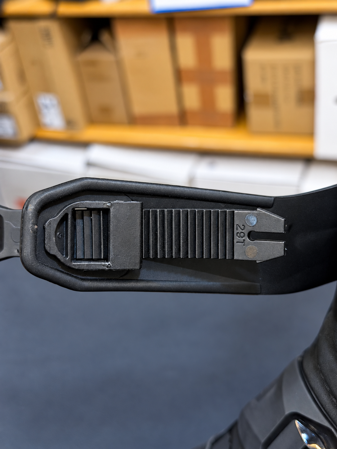 Close-up of the adjustable ratchet strap on a black Royal Enfield Wanderer riding boot, showing the toothed fastening mechanism.